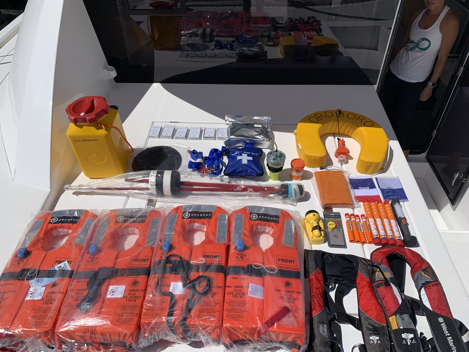 All the safety equipment laid out for inspection — life jackets, flares, tethers, EPIRB