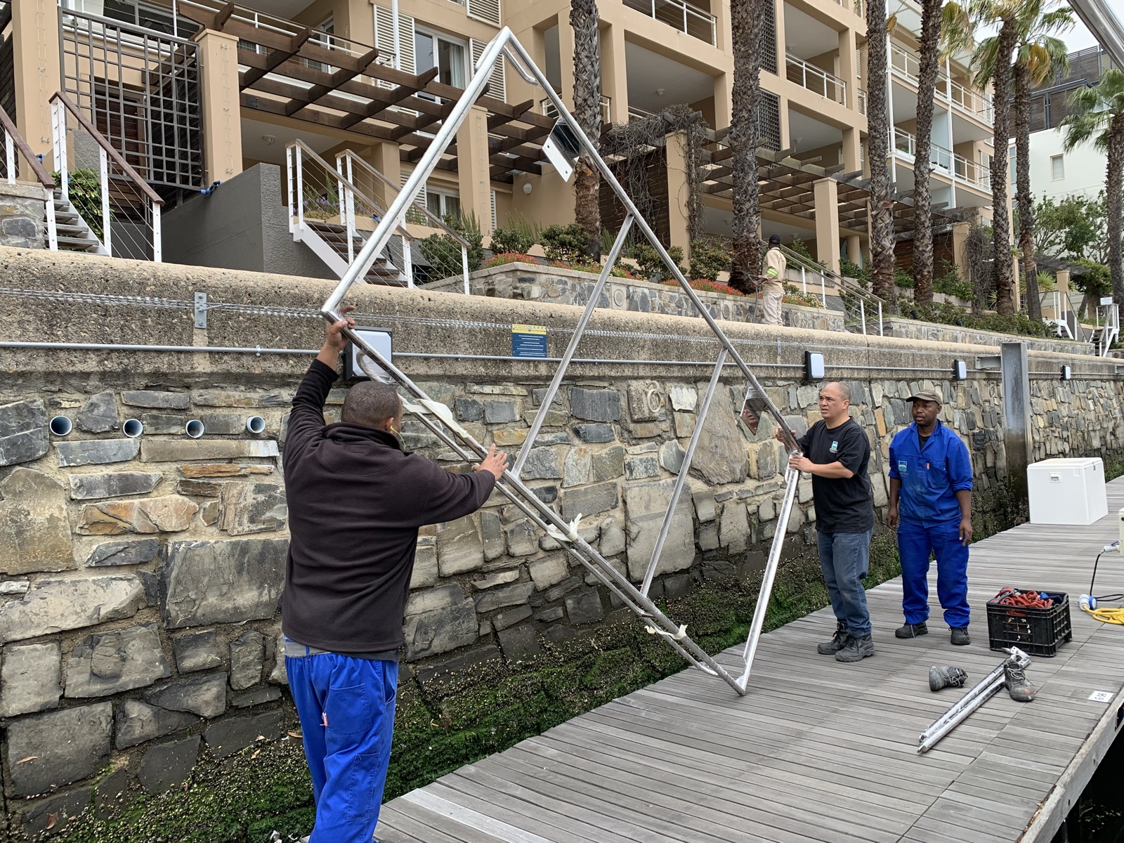 Fitting the solar panels to the arch on the dock before lifting it onto the boat