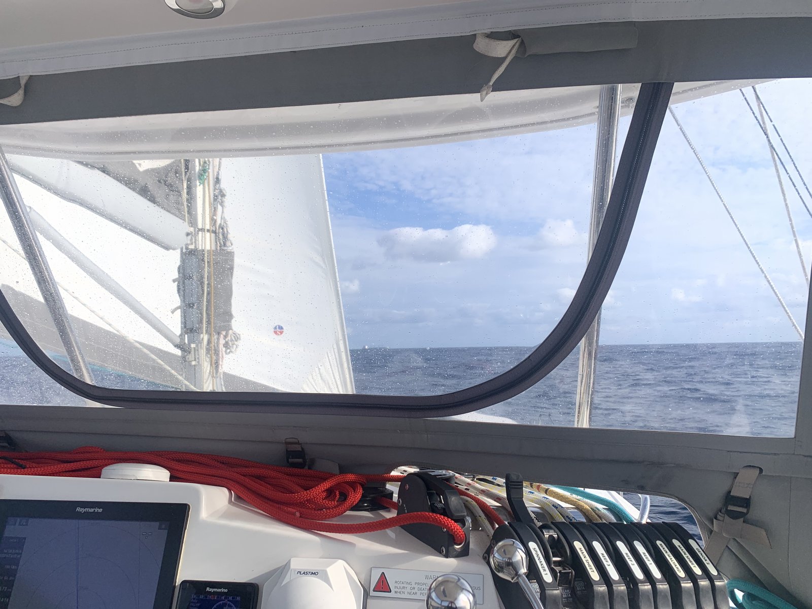 The helm station on a good day: chartplotter tracking the course, genoa pulling steady, and the sea doing what you ask of it.