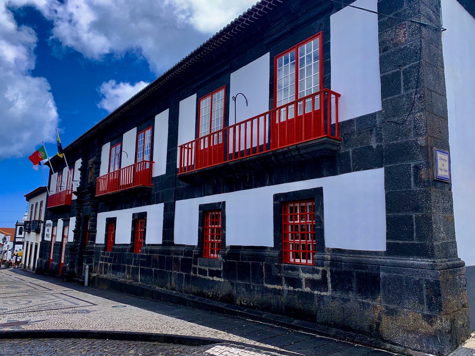 Traditional Azorean architecture — volcanic black stone and red shutters, Pico island.