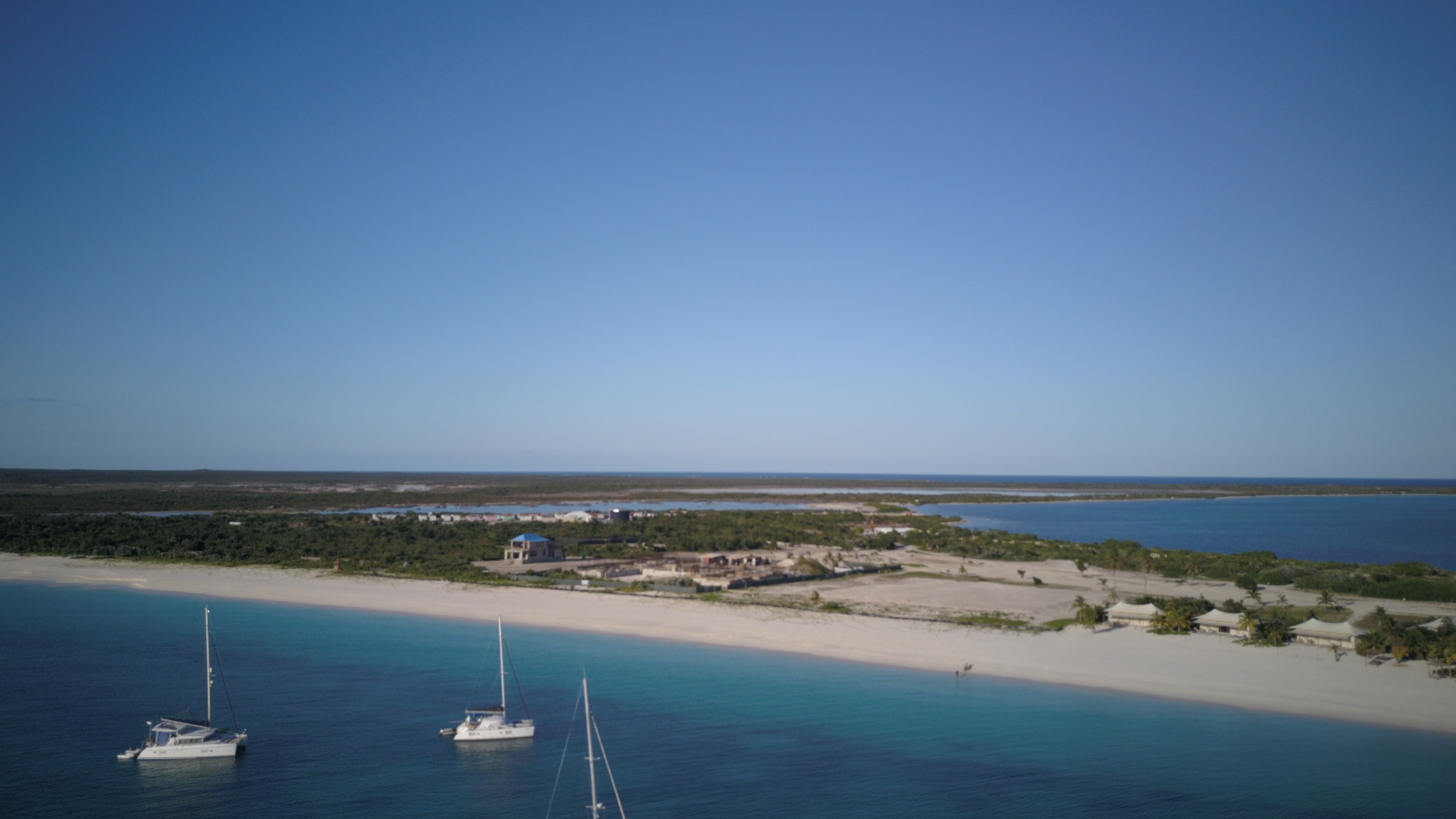 Barbuda from the air — Oroboro and a handful of boats anchored off a white sand beach with no one on it