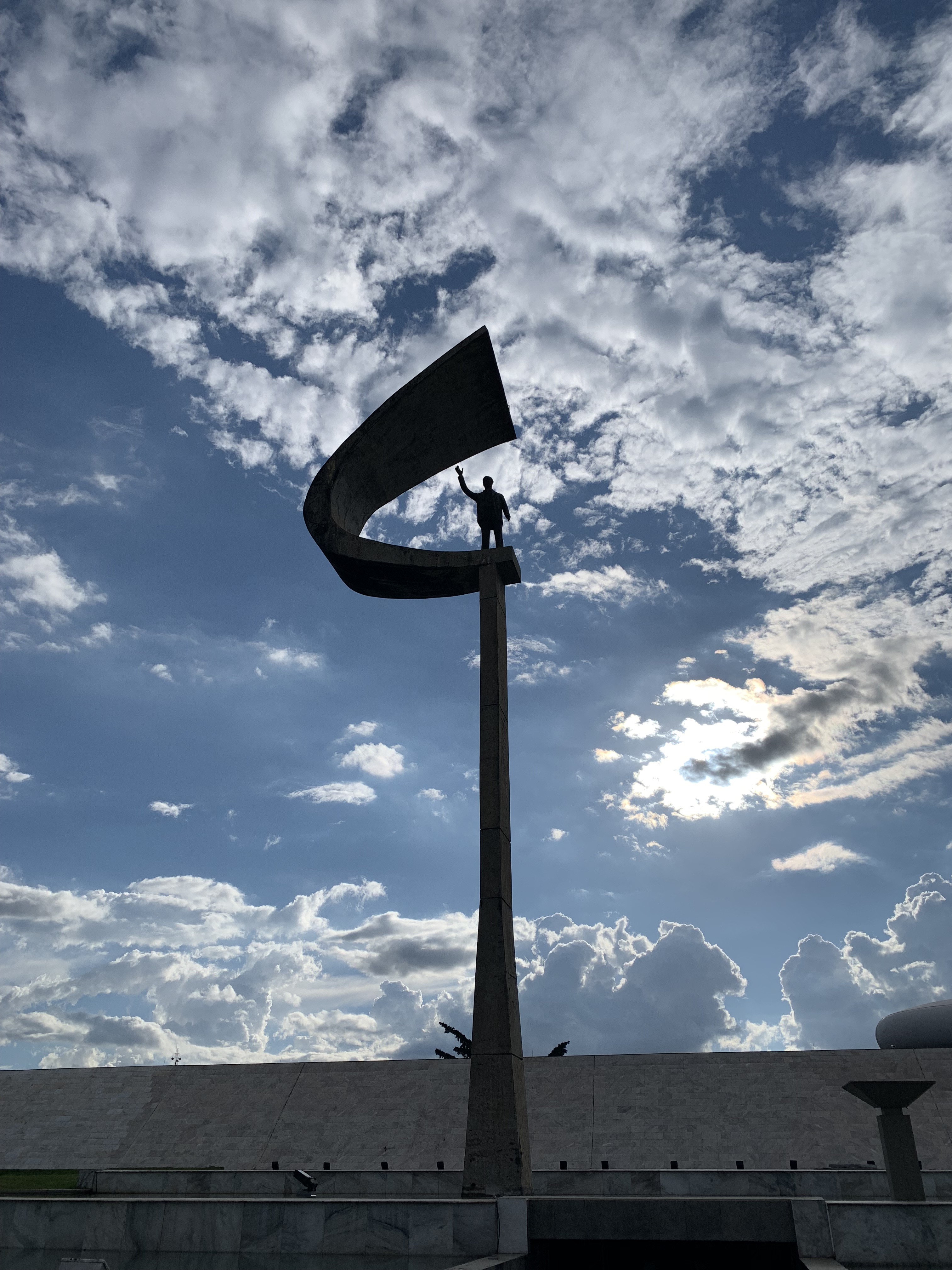 Monumento em bronze recortado contra o céu de Brasília na Praça dos Três Poderes