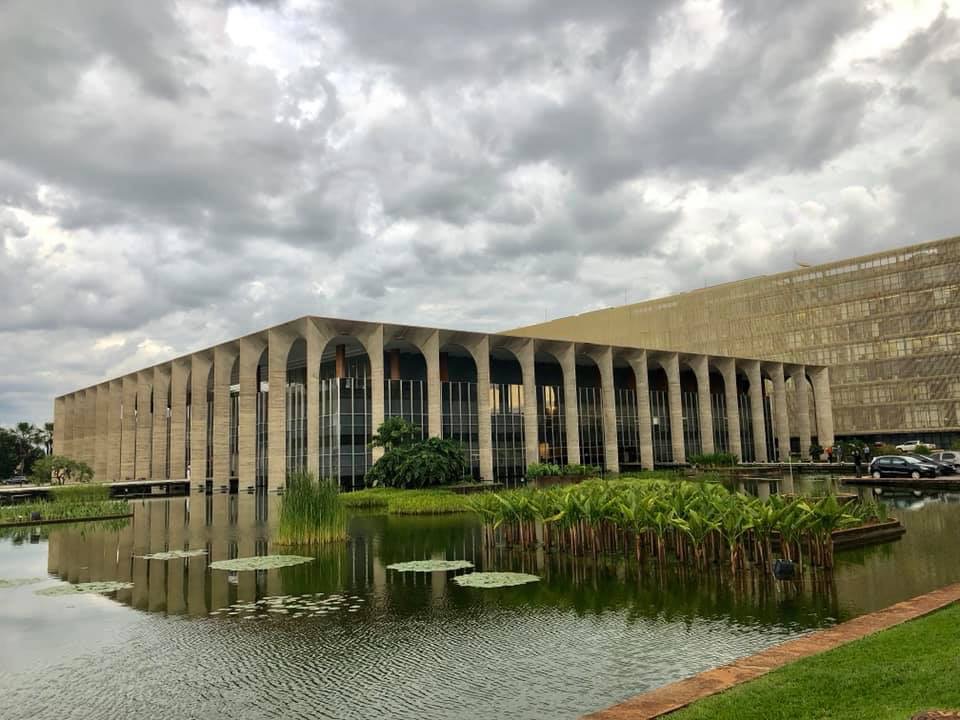 O Palácio do Itamaraty visto do jardim aquático — fachada de mármore com arcadas refletida entre vitórias-régias