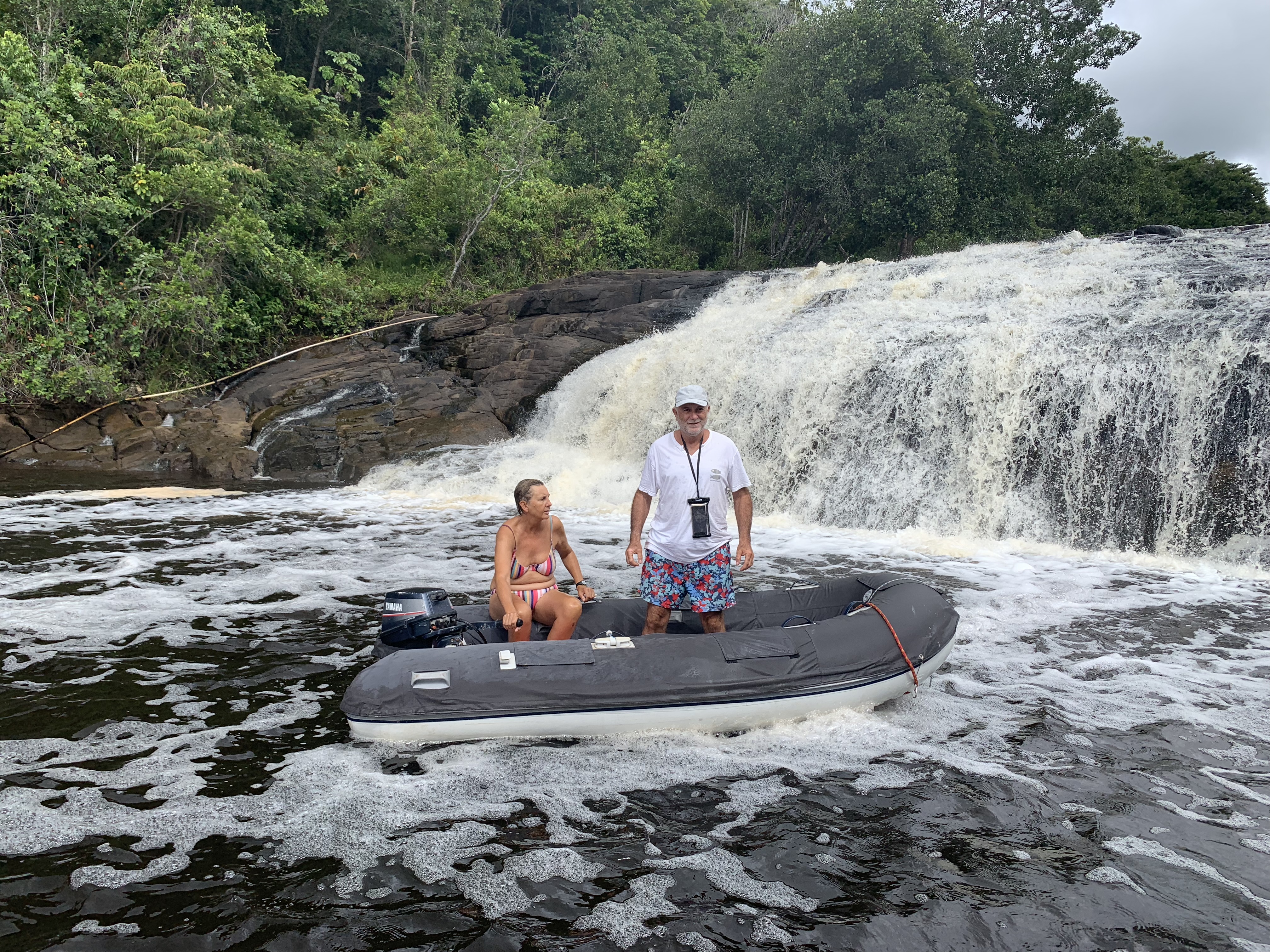 Francesco and Yuka standing in the shallows in front of a waterfall, Serra Grande