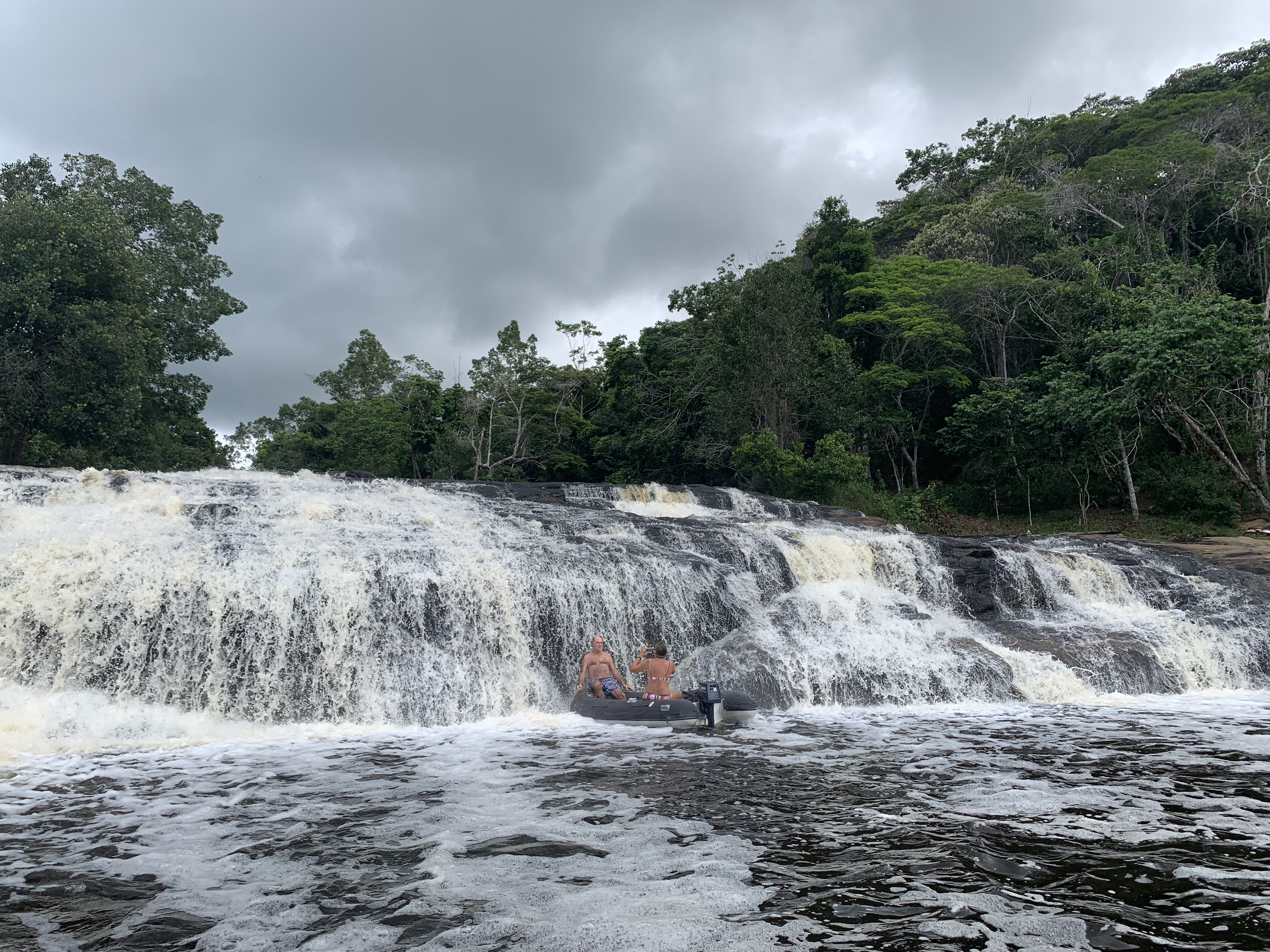 Wide low-angle view of the main cascade at Serra Grande with the dinghy visible