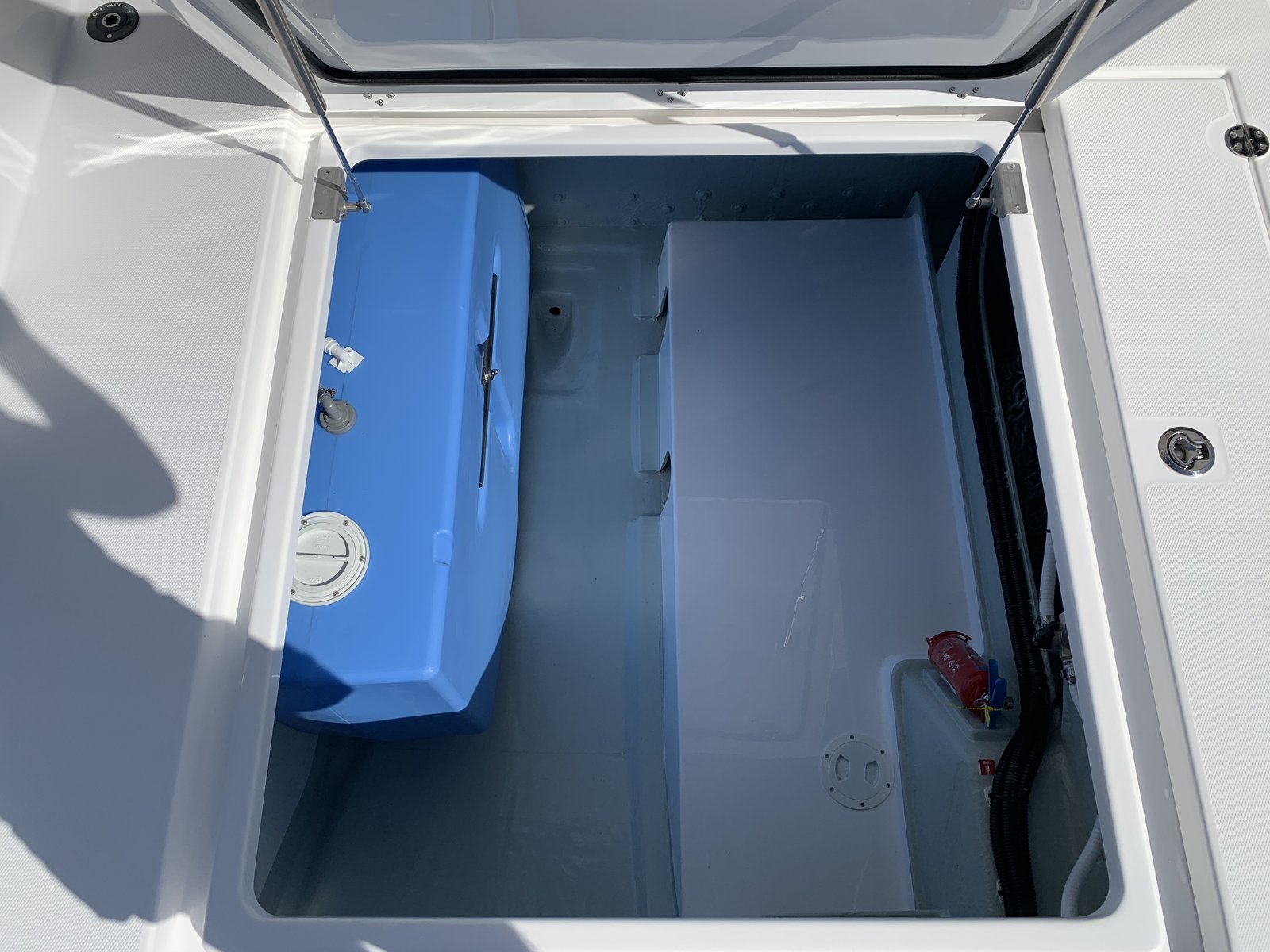 An open deck hatch revealing the hull storage space