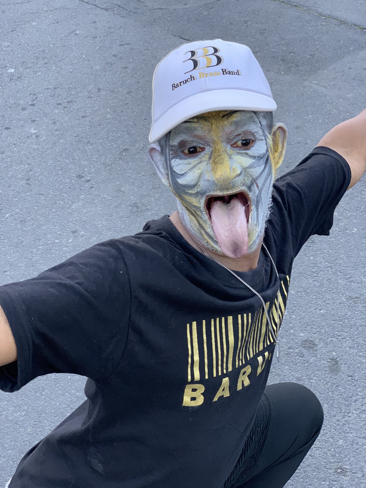 A festival performer with painted face from the Baruch Brass Band