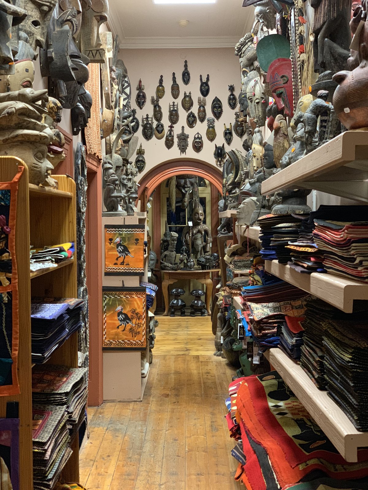 Inside an African art and curios shop packed with masks, textiles, and carvings