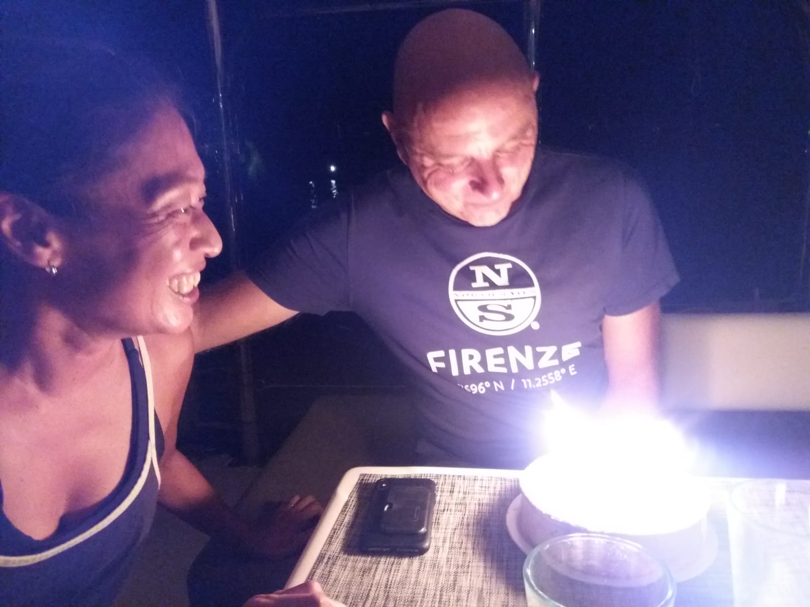 Francesco blowing out the birthday candle — Yuka watching with a big smile