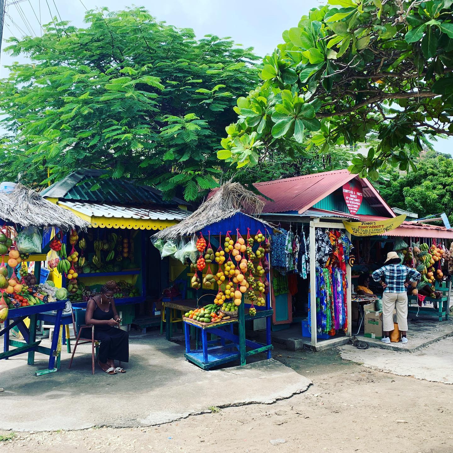 Colorful open-air market stalls with tropical fruit and souvenirs
