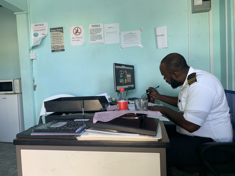 Clearing customs — the officer at his desk, papers and stamps at the ready