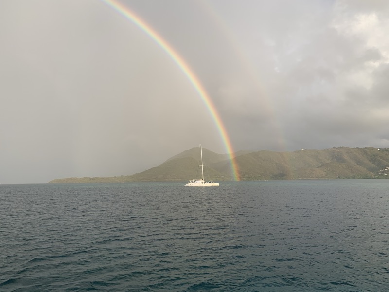 A double rainbow arching over a catamaran at anchor — one of those Caribbean moments