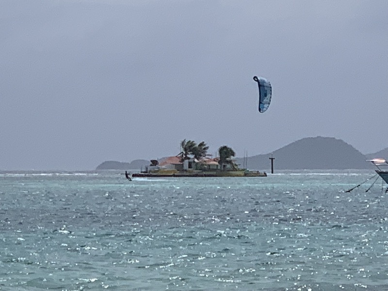 A kite in the air near Happy Island — the tiny man-made bar island in Union Island's lagoon