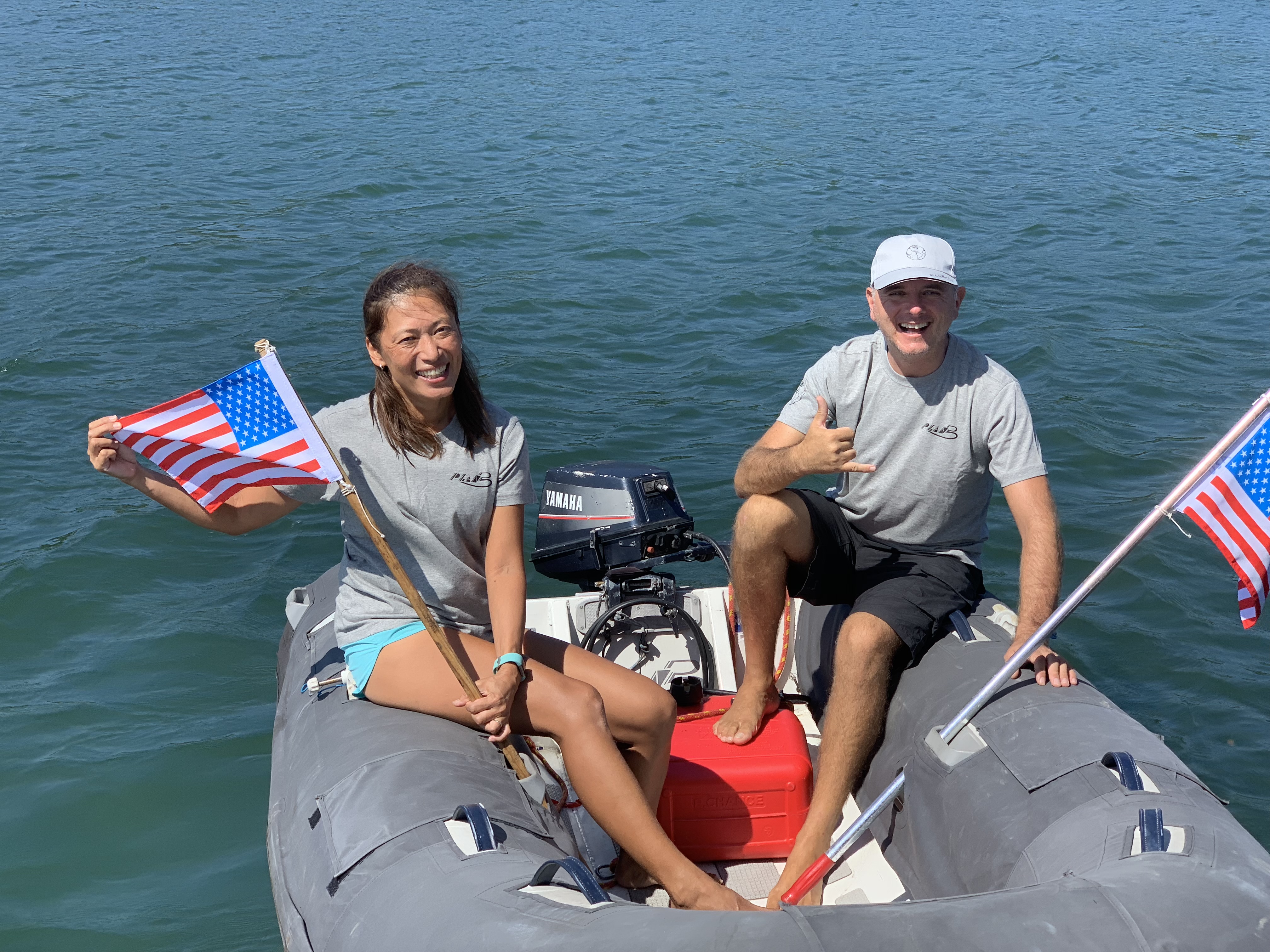 Yuka e uma amiga no bote com pequenas bandeiras americanas, celebrando o Quatro de Julho na Bahia de Todos os Santos