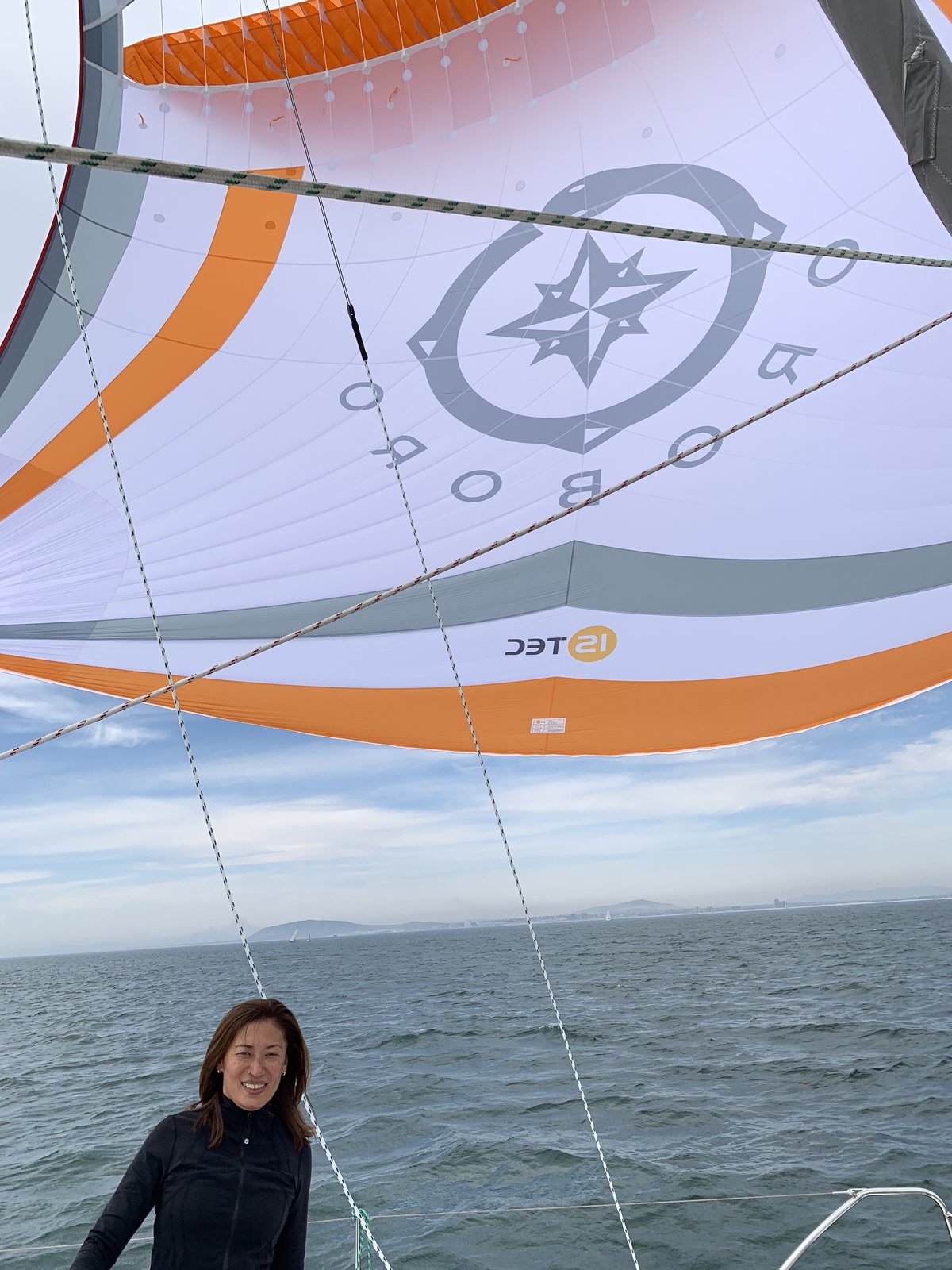 Yuka under the Oroboro parasailor on its first test — the custom compass logo on orange and white