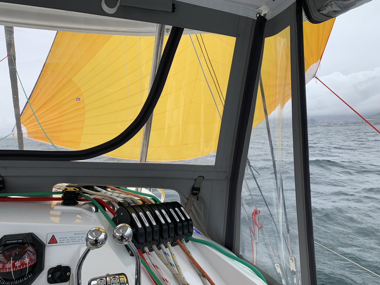 The yellow parasailor pulling Oroboro on a grey day off Cape Town