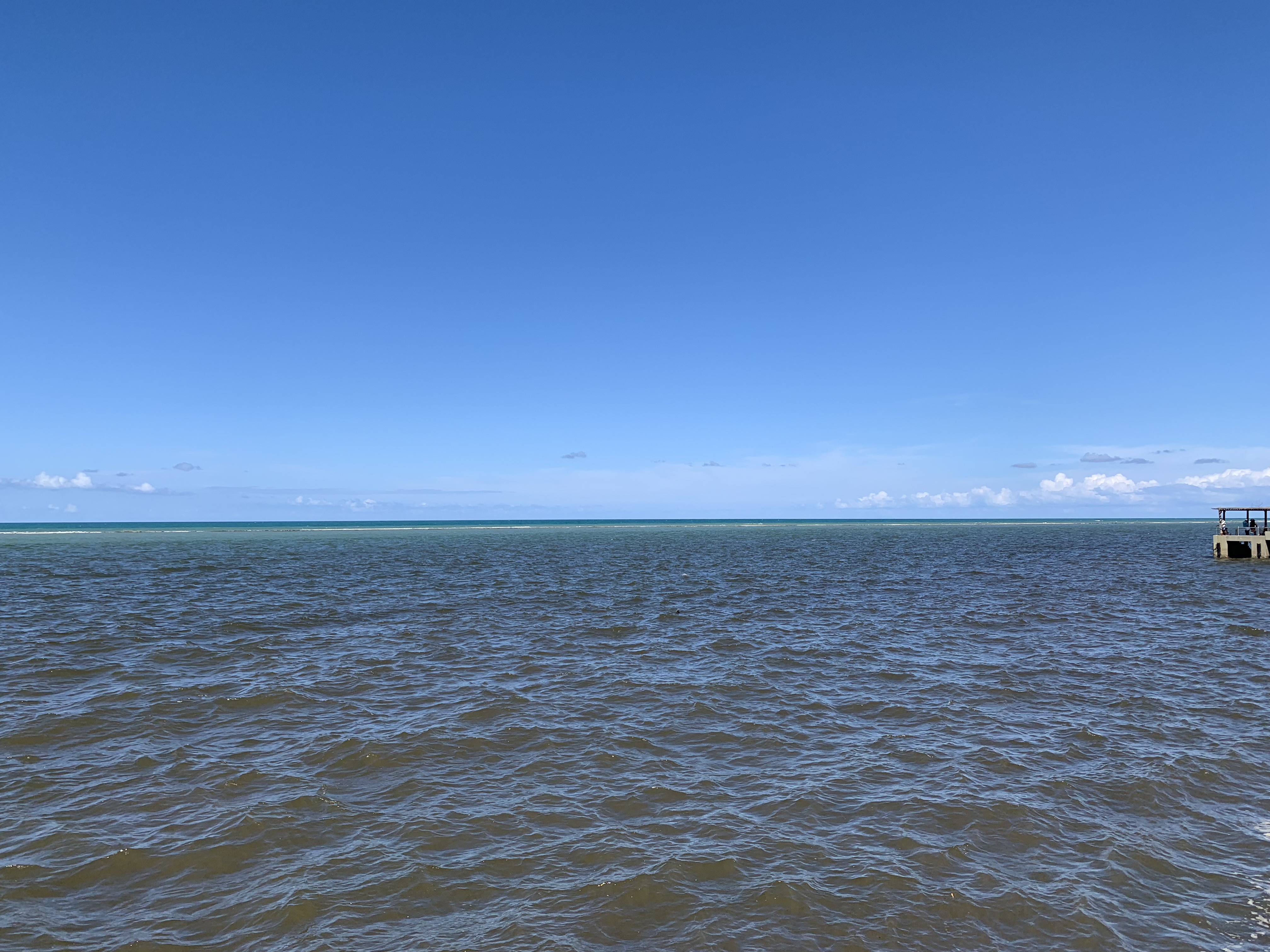 Turquoise reef line visible beyond the river entrance at Porto Seguro