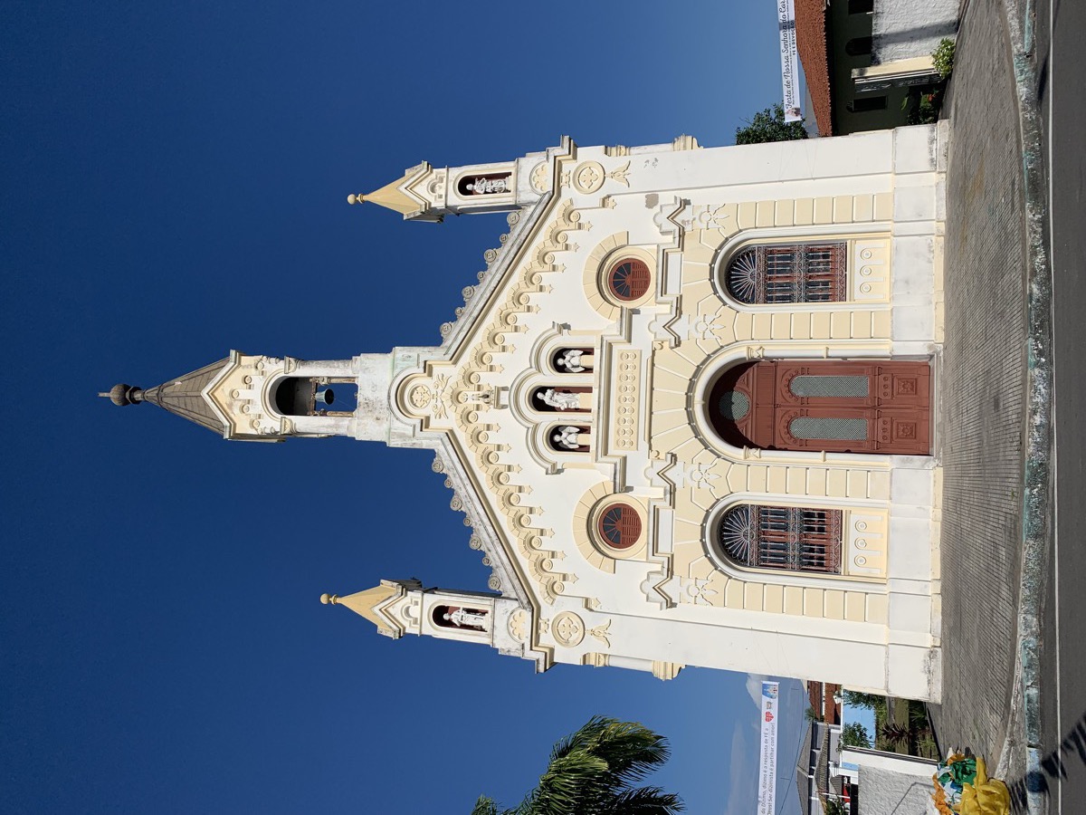 A igreja matriz neoclássica de Salinas da Margarida com sua fachada branca, torre central única, torres laterais e nichos repletos de santos