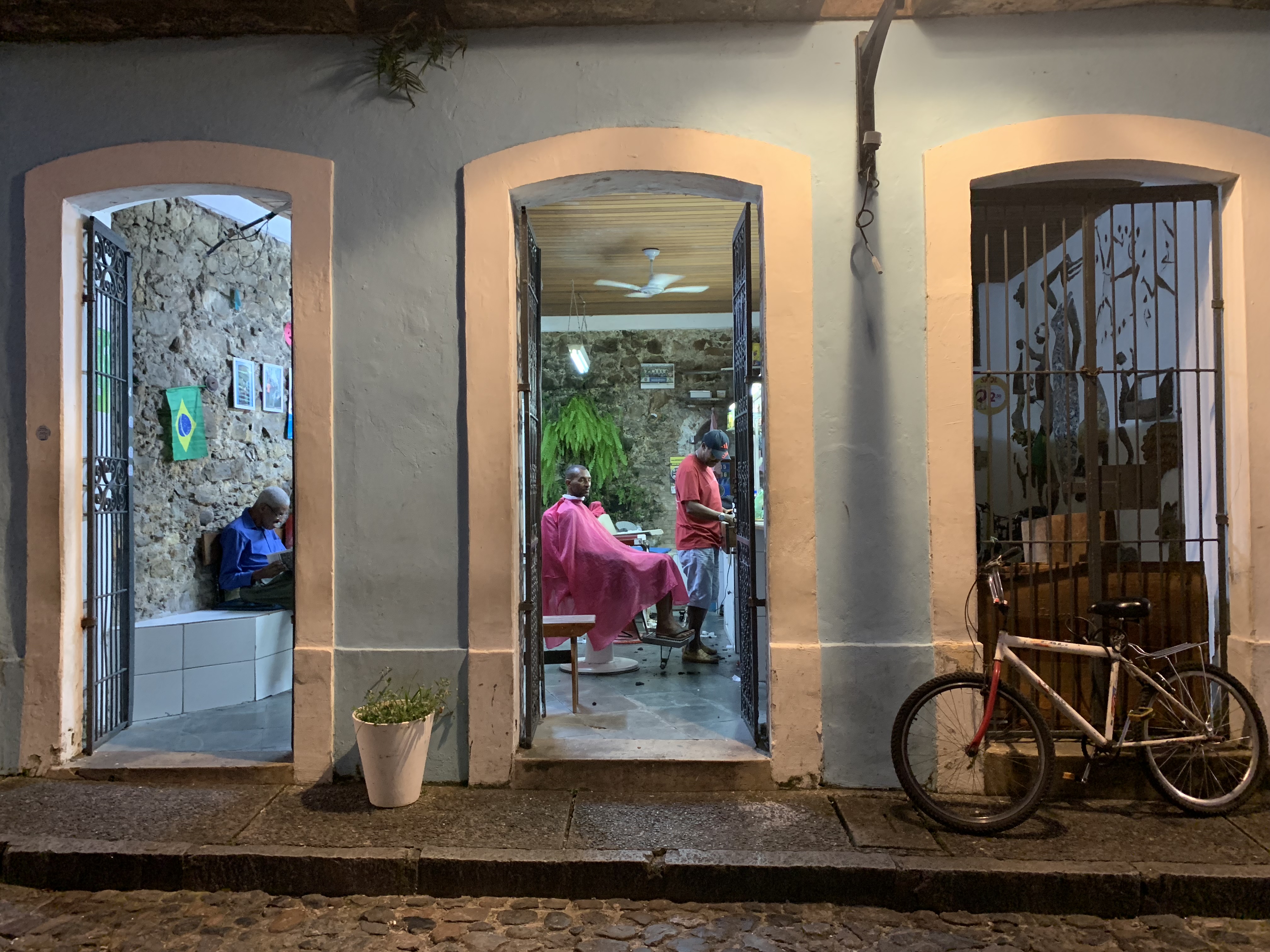 A barbershop at night through an open colonial doorway