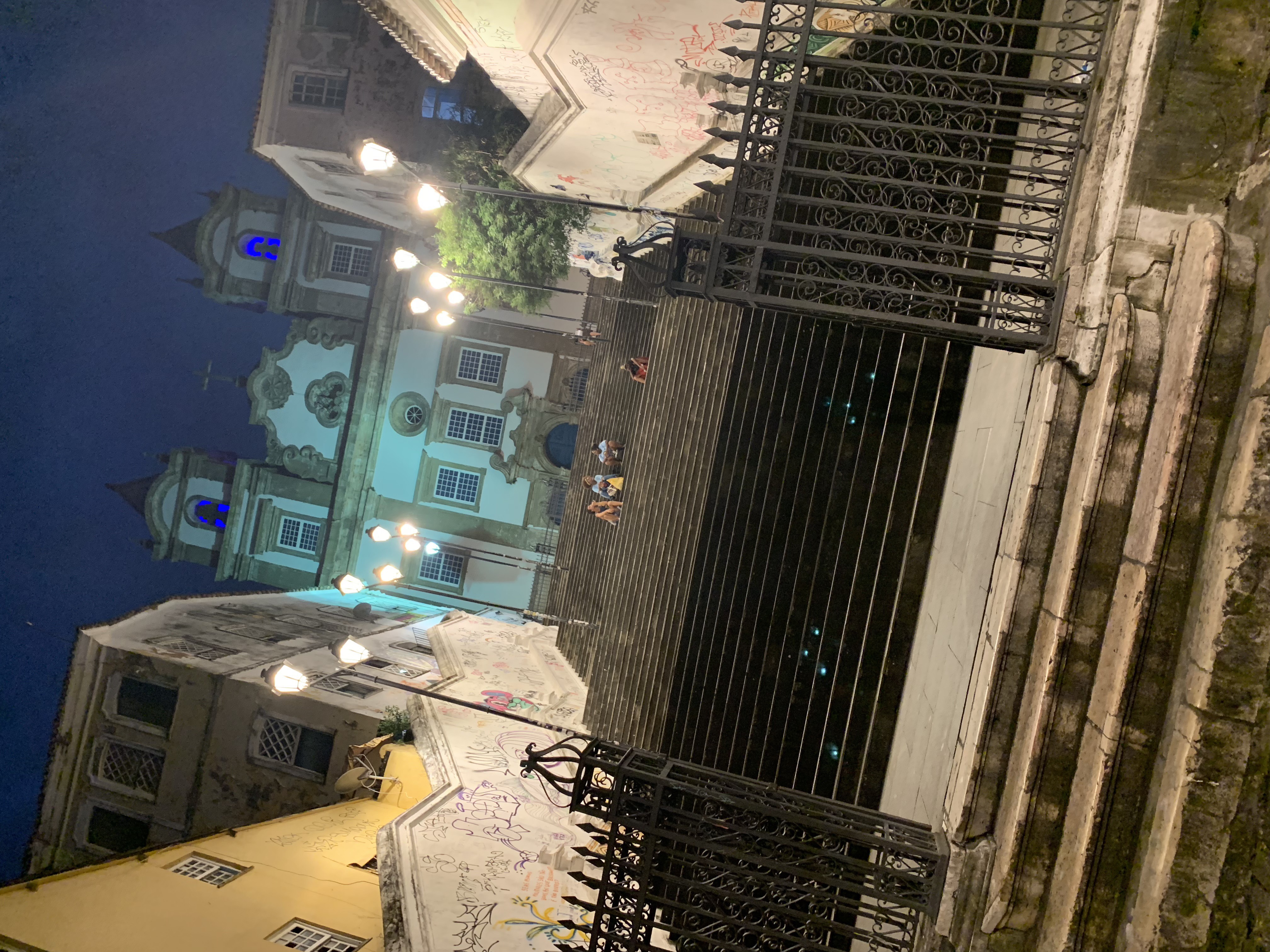 Igreja Nossa Senhora do Rosário dos Pretos at night through an iron gate