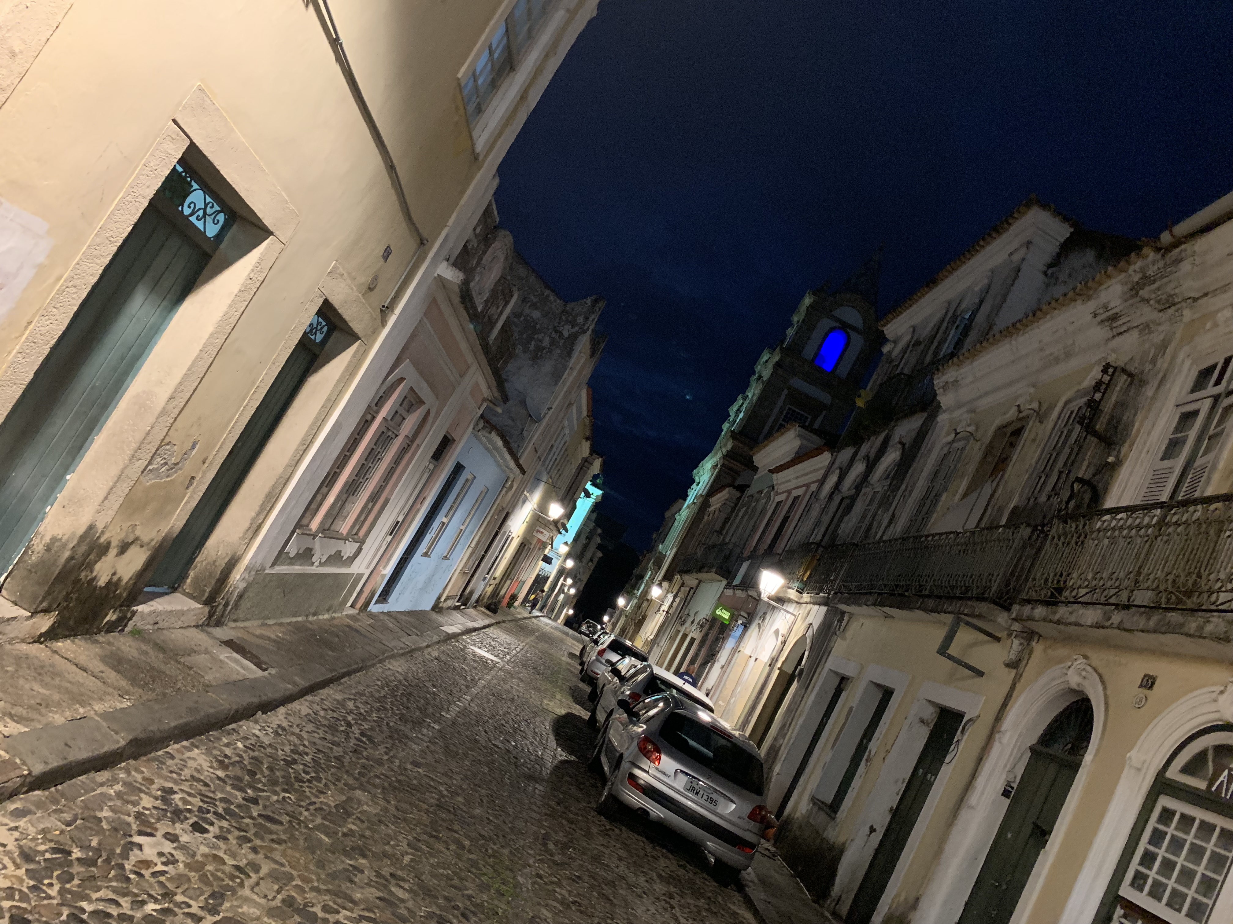 Pelourinho cobblestone street at night with parked cars