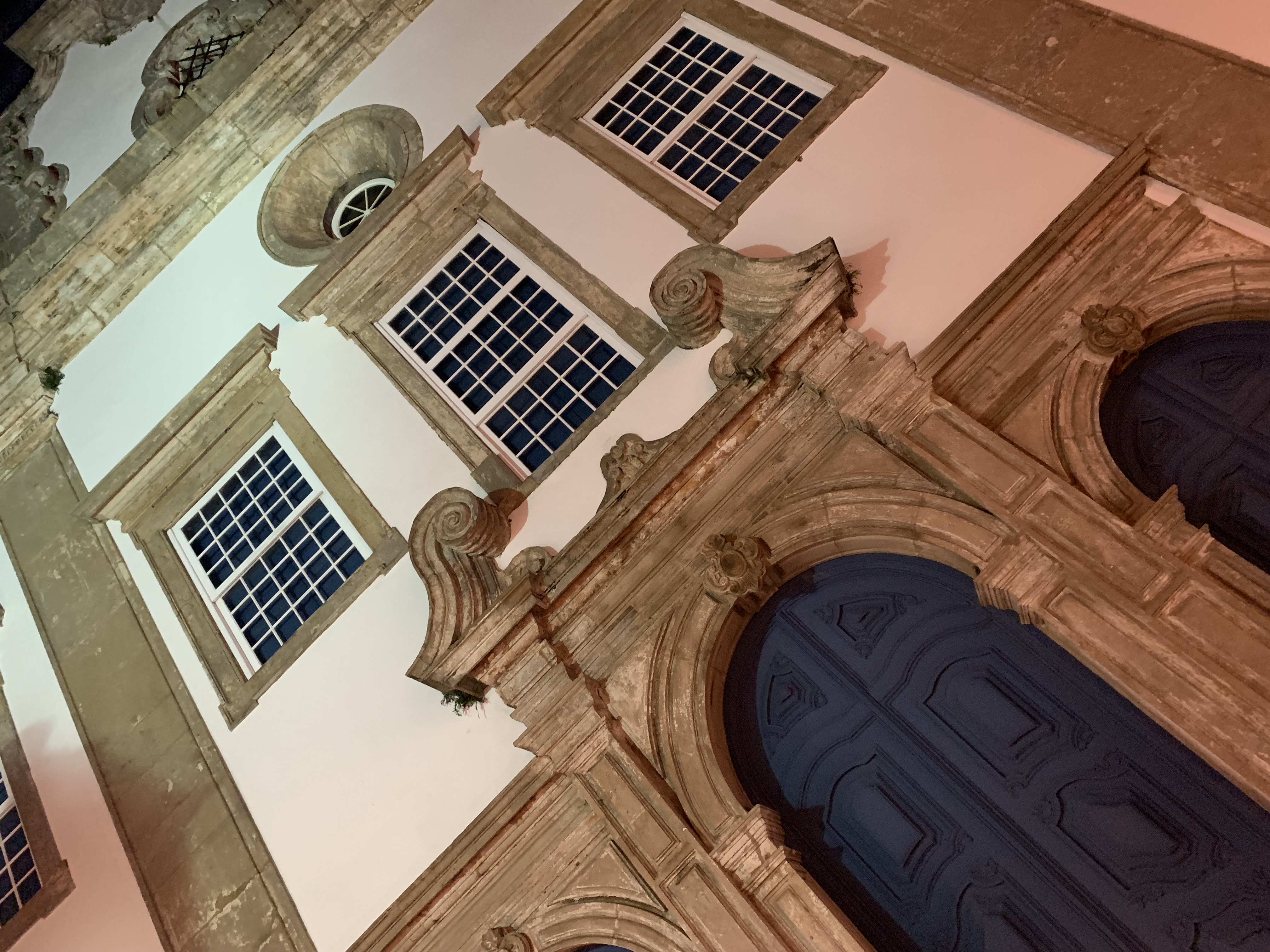 A baroque church entrance from below at night