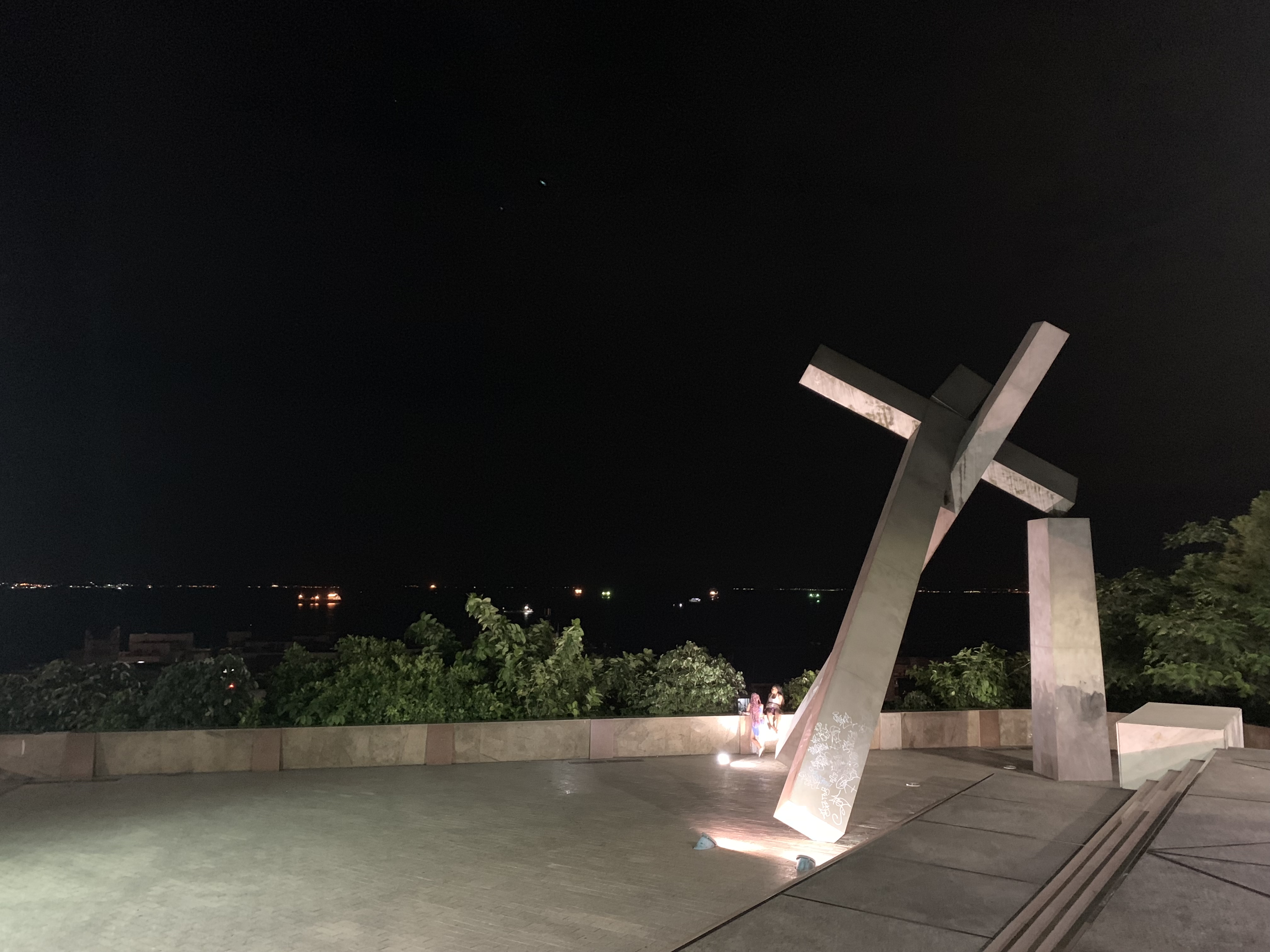 The stone cross monument overlooking the Baía de Todos os Santos at night