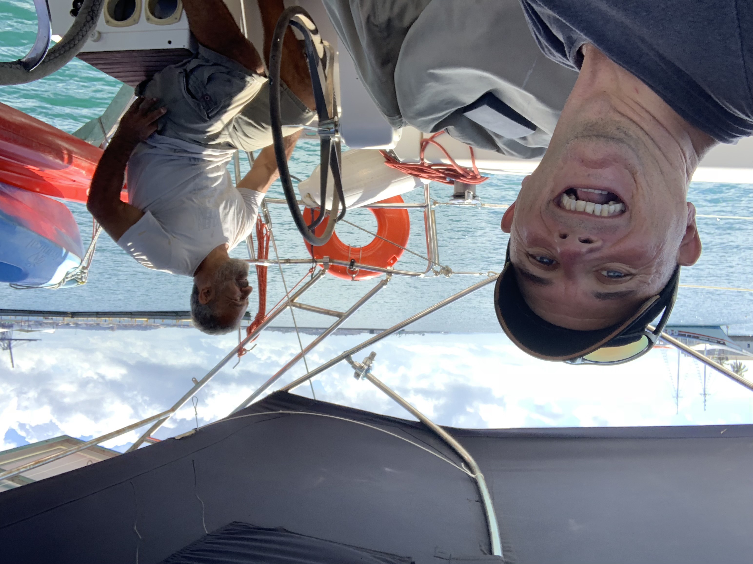 Francesco and a local boat helper on Oroboro's cockpit