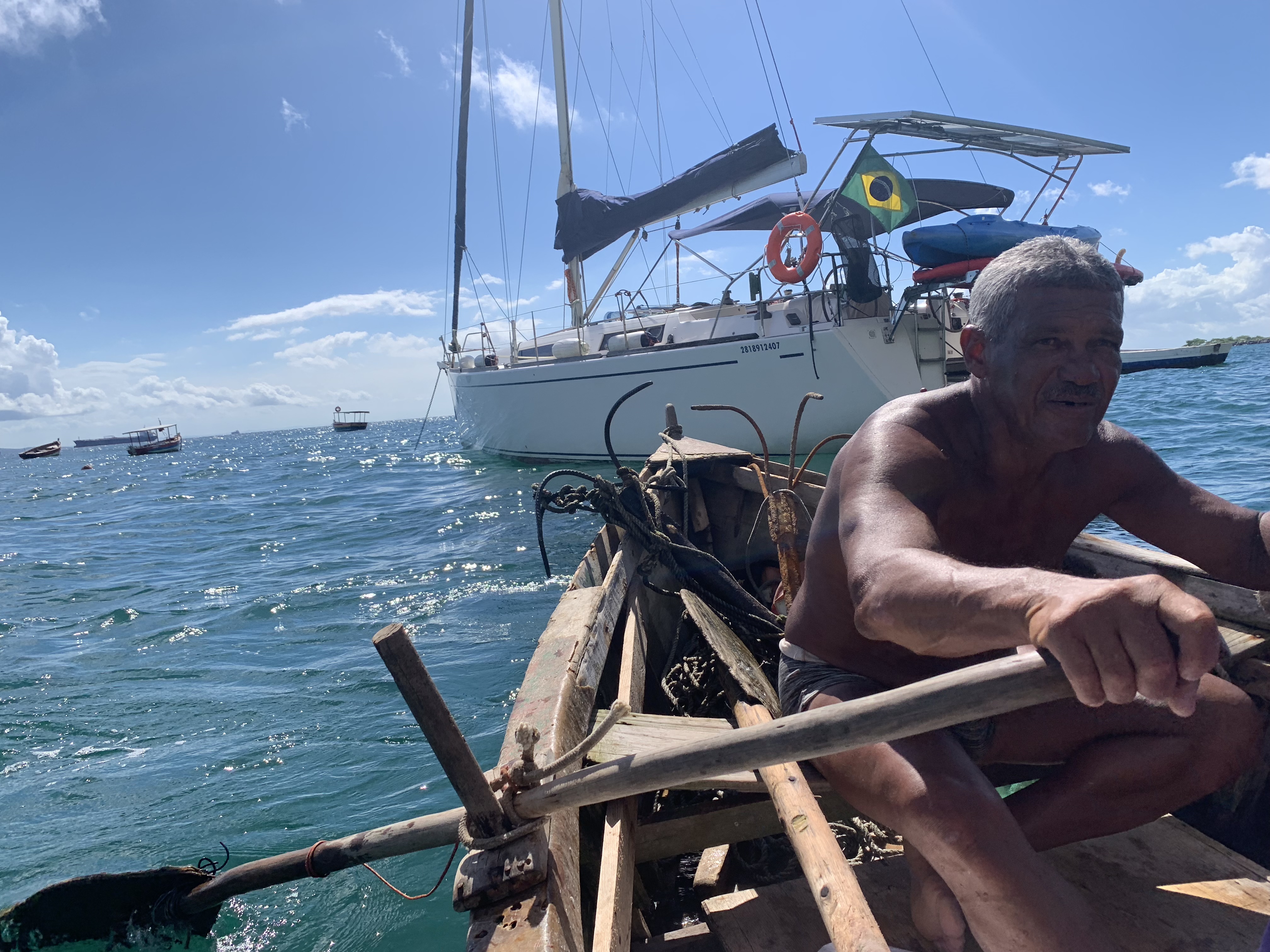 A local fisherman on a rustic wooden rowing raft with Oroboro behind