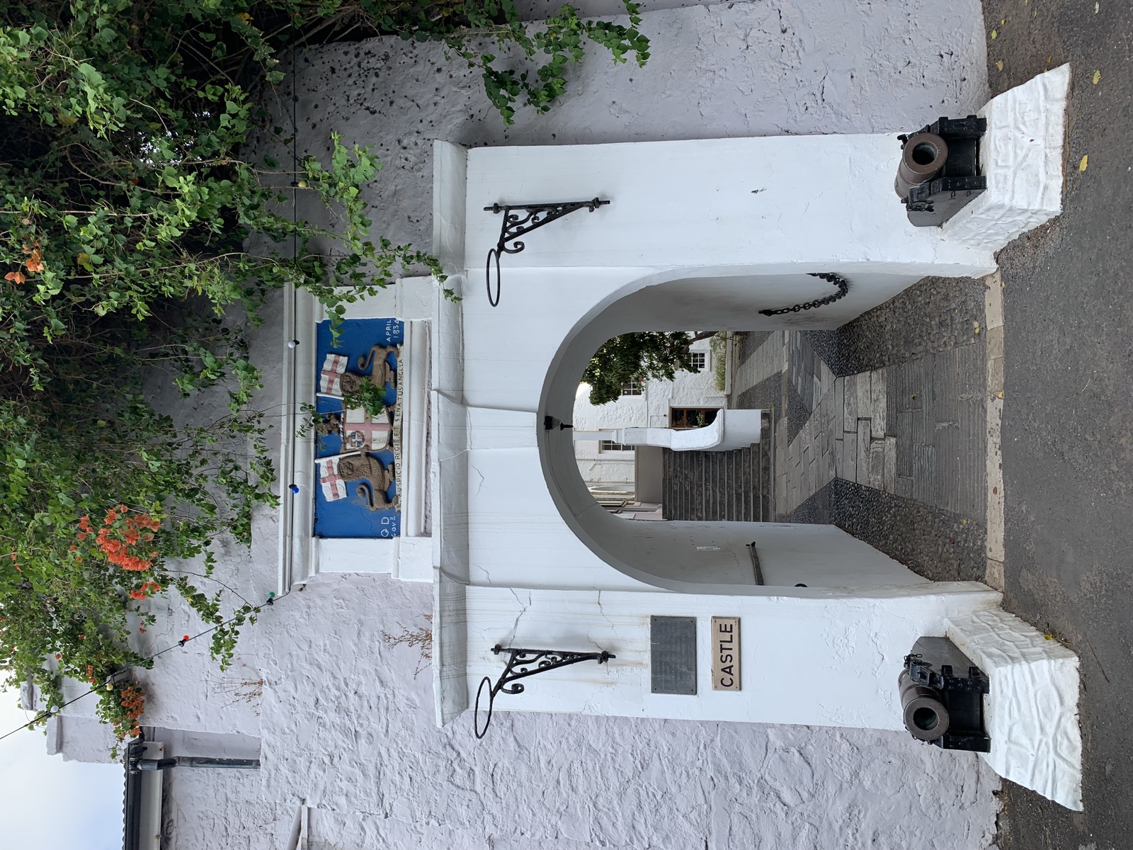 The entrance to the Castle of St Helena — a white arch gate inscribed 'CASTLE' with cannons flanking the archway