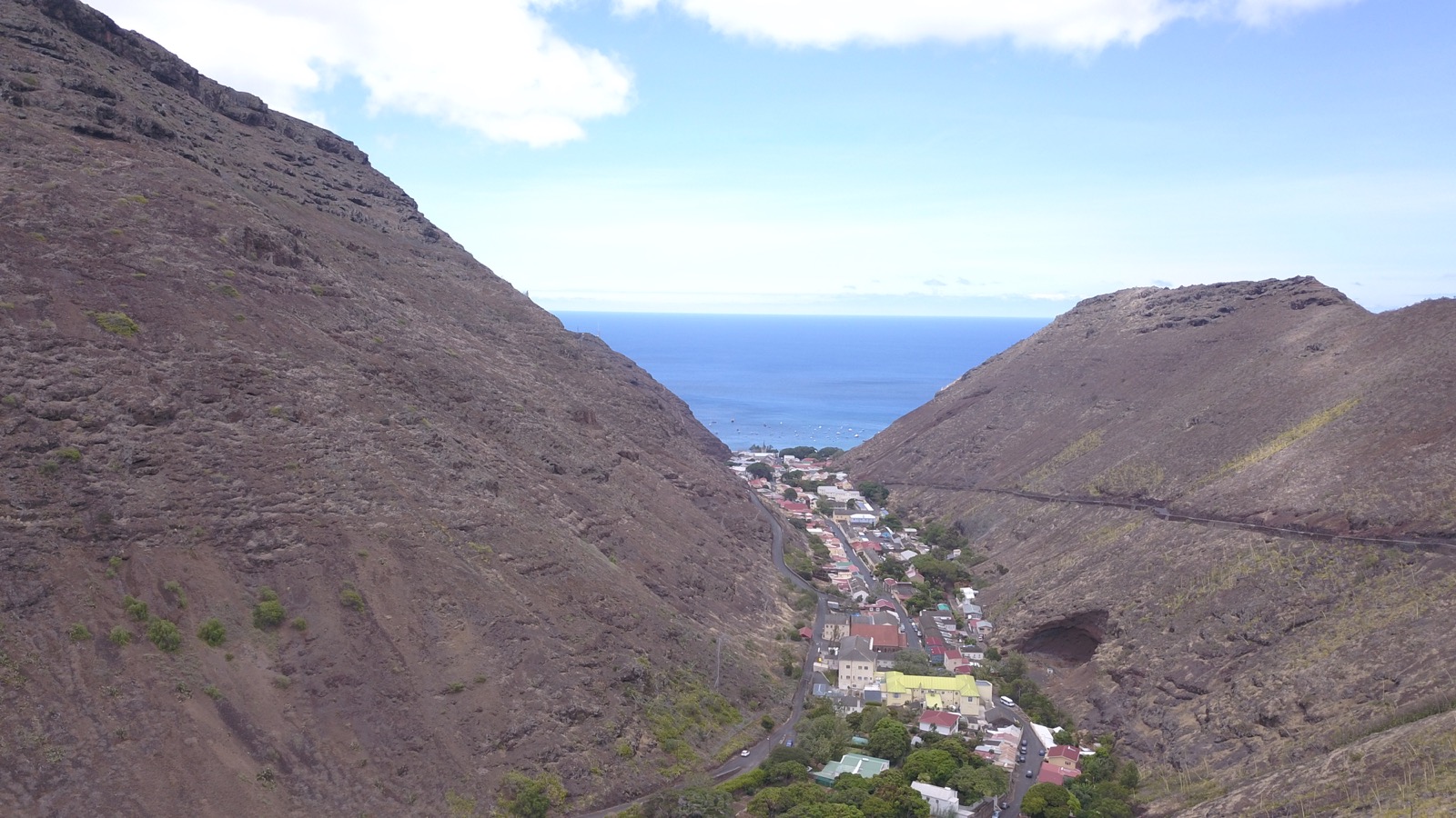 Aerial view of Jamestown from above — the town nestled between two steep black volcanic ridges with the South Atlantic at the end of the valley