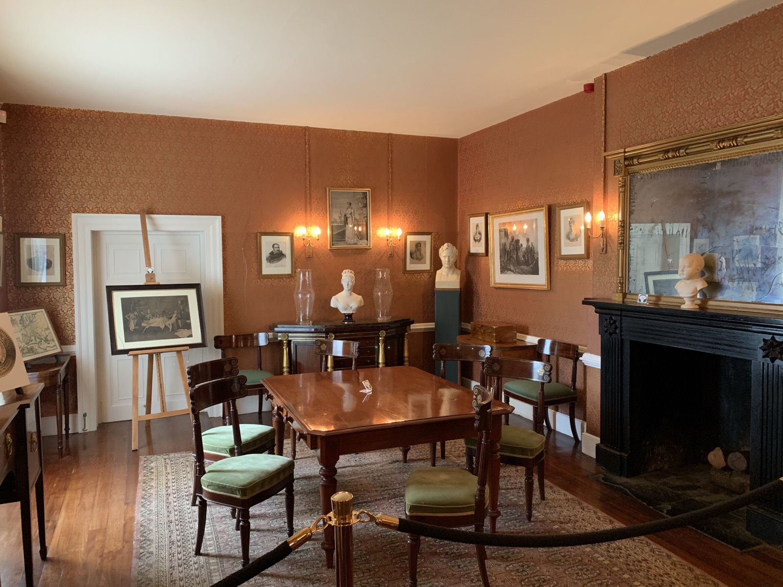 The reception room at Longwood House — Napoleon busts, mahogany table, period chairs and fireplace