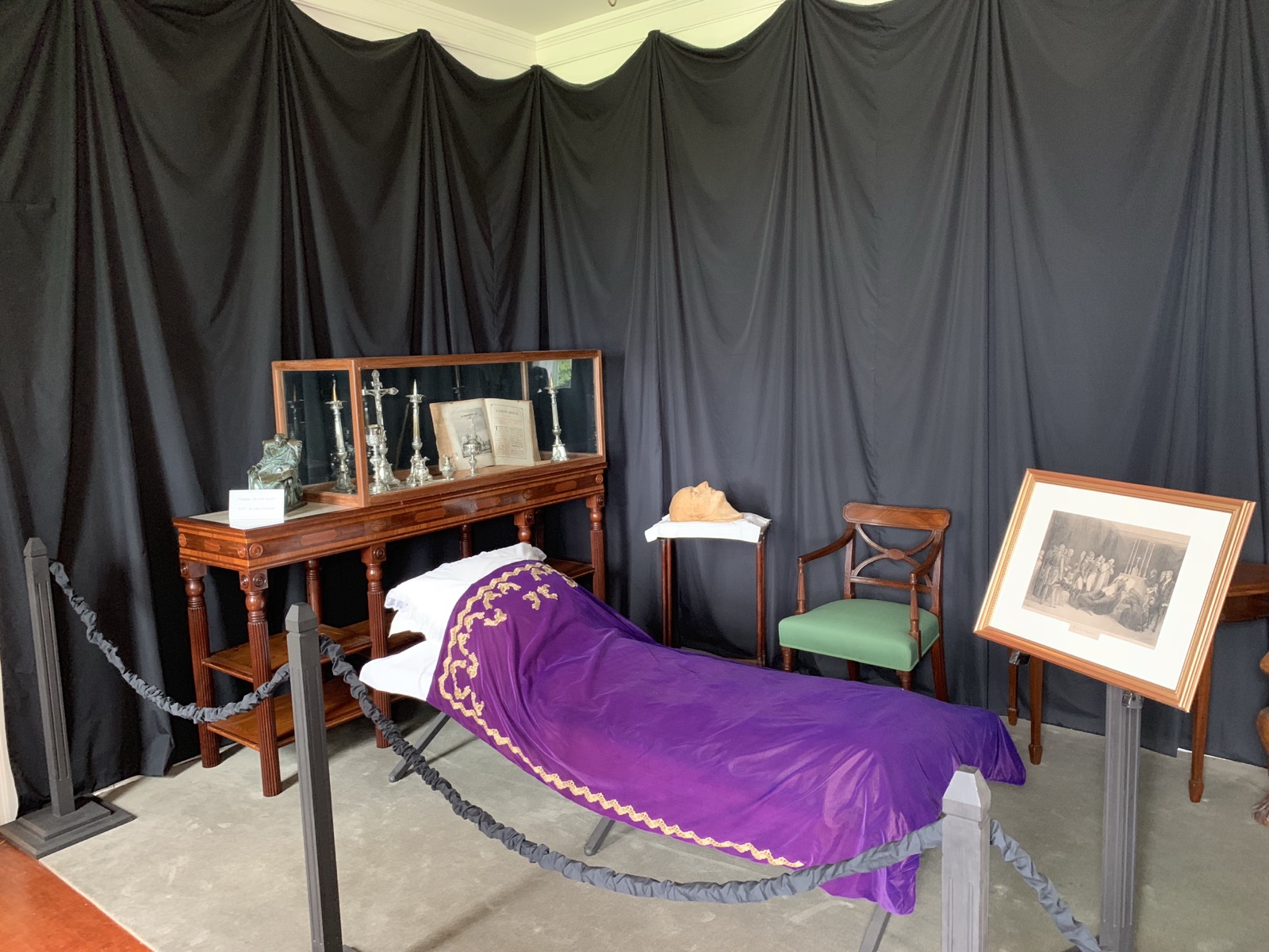 The room at Longwood House where Napoleon died — a cot draped in purple cloth with imperial gold bees