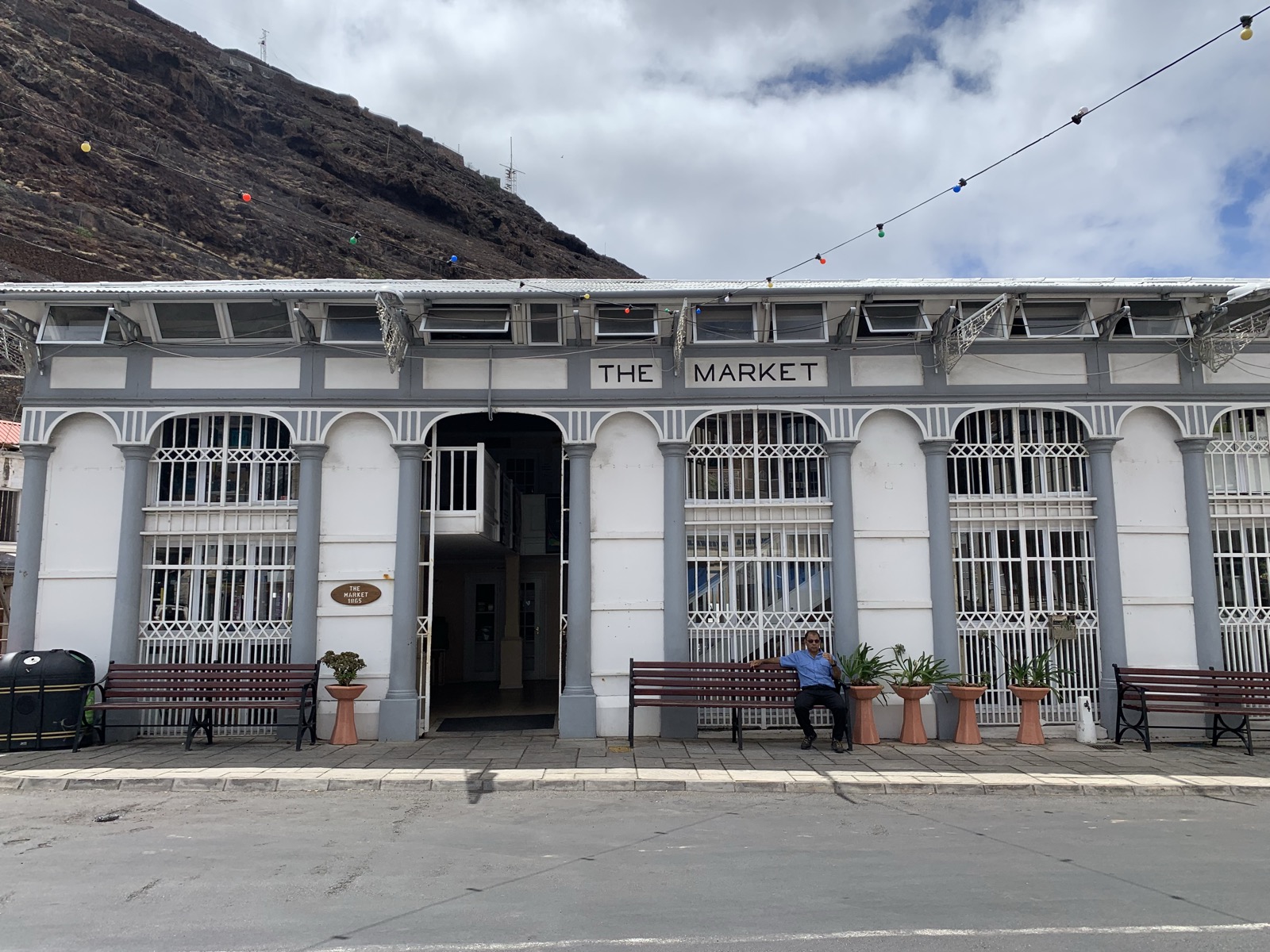 The Market building in Jamestown — a white and grey colonial market hall with arched windows and decorative ironwork, volcanic ridge visible behind