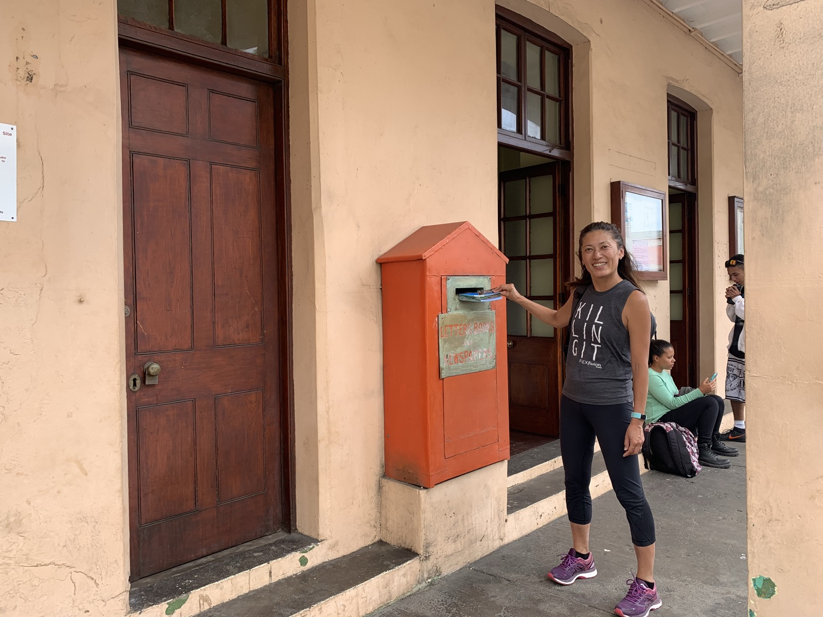 Yuka posting a letter at the vintage red British post box outside the Jamestown Post Office
