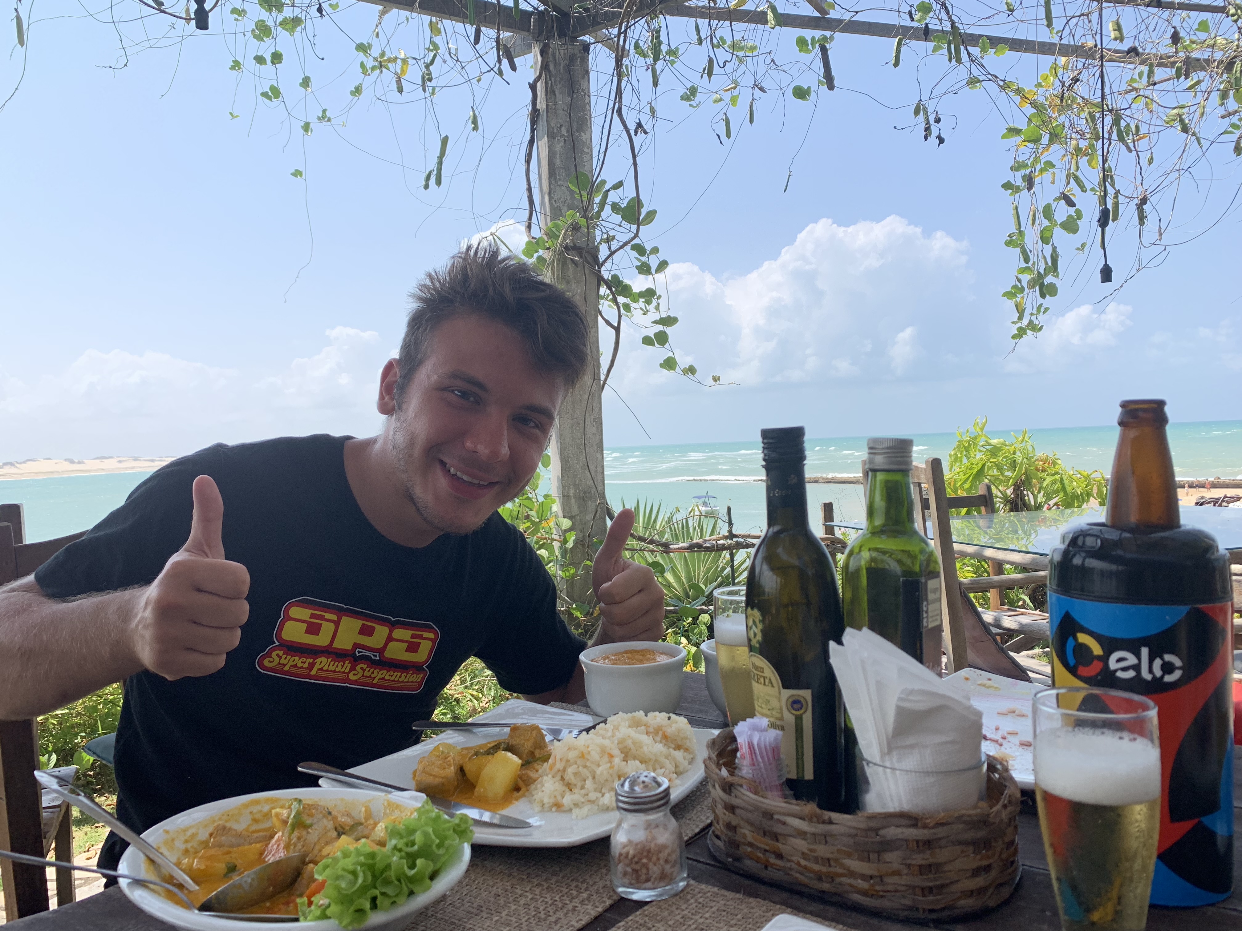 Mario em um restaurante à beira-mar — frutos do mar frescos com o oceano turquesa ao fundo