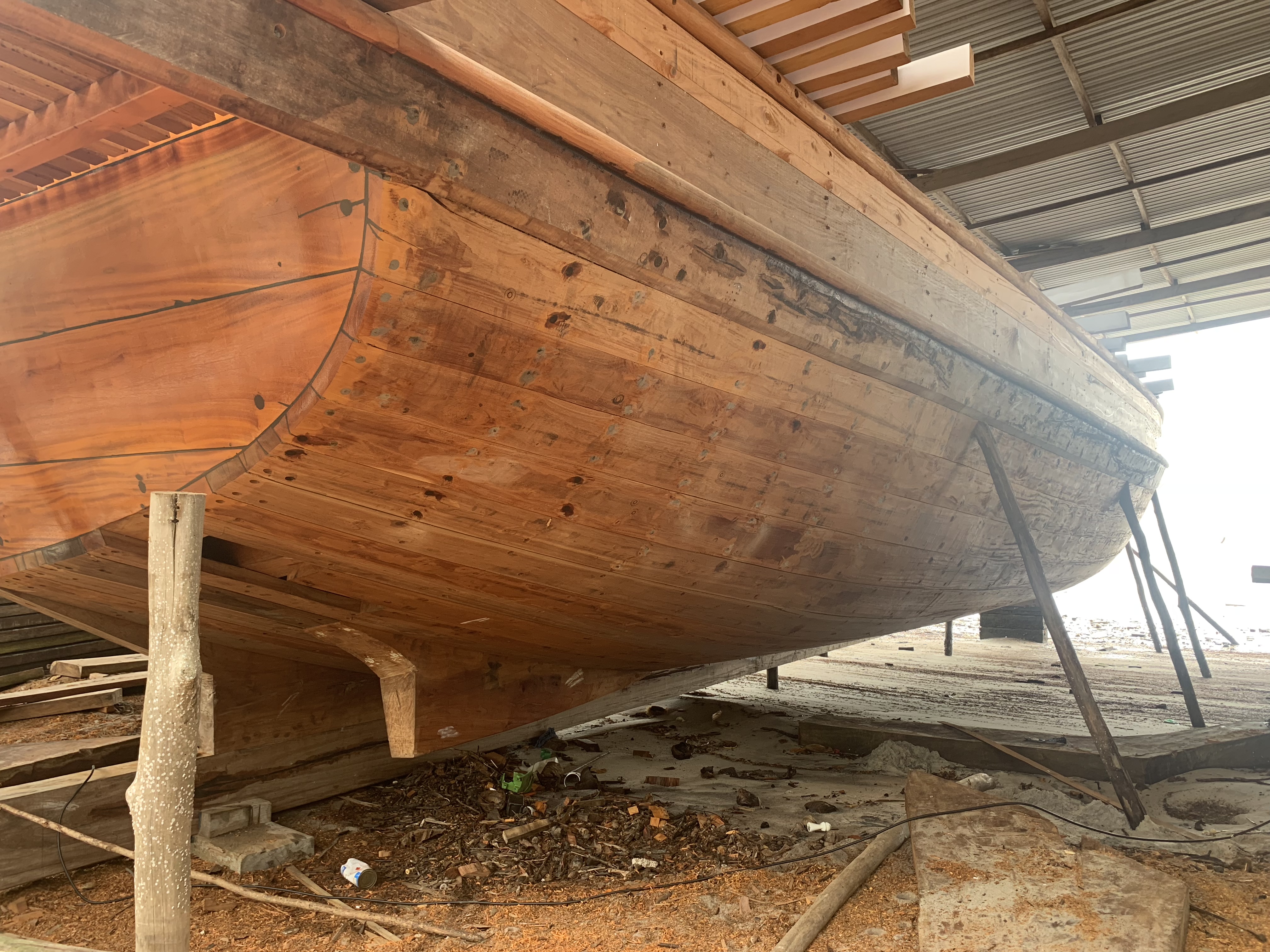 Close-up of a wooden hull showing the natural grain of the planks and the unpainted wood surface